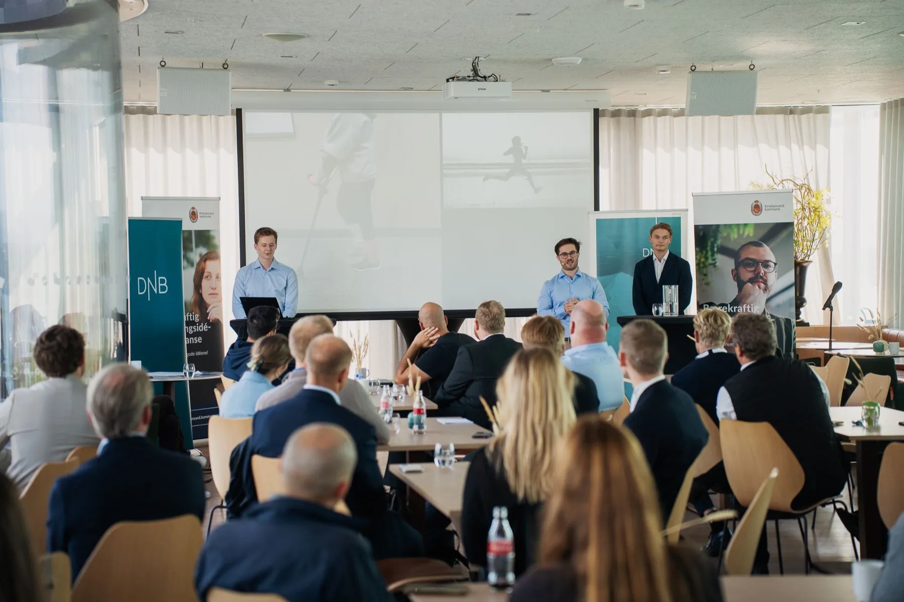 Teamet i NeuroFlex Robotics presenterer for et publikum på et arrangement